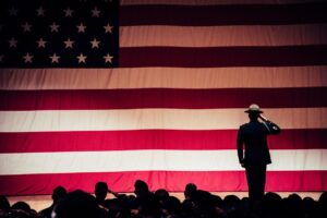 Man Standing On Stage Facing An American Flag